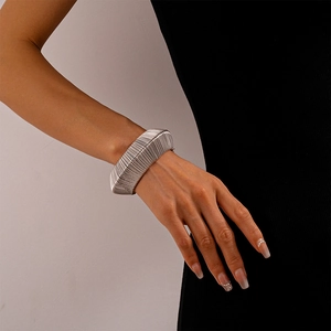 Detailed macro view of the silver woven geometric wide cuff bracelet on a model's wrist