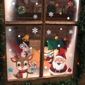 Close-up of festive Christmas window decals featuring Santa, reindeer, and snowflakes