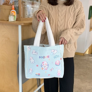 Detail der hellblauen Canvas-Tasche mit Plüschgriffen und süßen Cartoon-Hasenmotiven