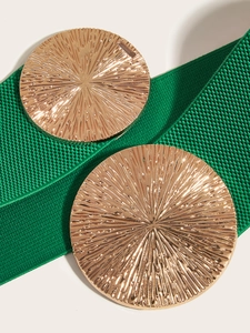 Macro view of wide elastic waist belt with textured gold metal sunburst buckle