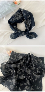 Detail of a black floral cotton-linen scarf with white flower patterns and rolled edges