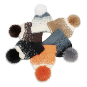 Set of six colorful knit beanies with faux fur pom-poms for winter warmth