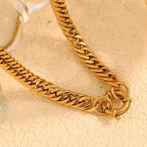 Macro detail of 18K gold plated thick Cuban link chain with a spring ring toggle clasp