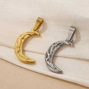 Macro view of gold and silver crescent moon pendants with hammered metal texture