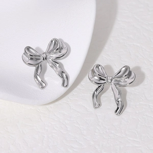Polished silver bow knot stud earrings in stainless steel on white background