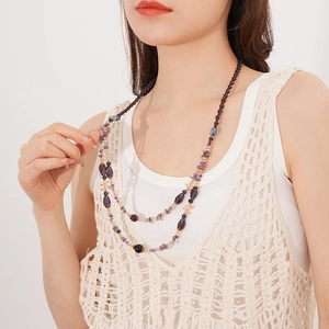 Detailansicht einer doppellagigen Boho-Halskette mit violetten Amethyst-Glasperlen an einem Model