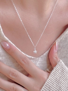 Macro shot of 925 sterling silver star pendant necklace with cubic zirconia on a model