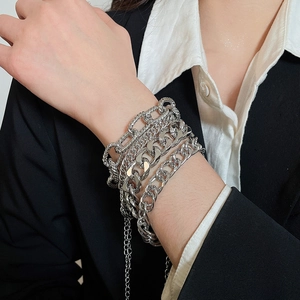 Detailed view of layered silver metal Cuban chain bracelets with adjustable clasp