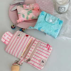 Detail of floral and striped mini coin purses with snap buttons and cupcake charms