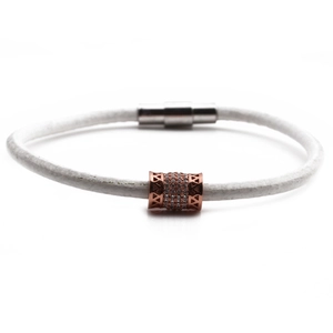 Dettaglio del bracciale in pelle bianca con ciondolo in zircone oro rosa e chiusura magnetica