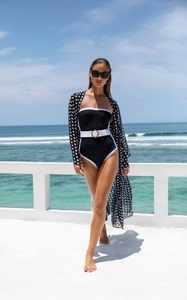 Detail of black one-piece swimsuit with white trim and matching polka dot chiffon cover-up