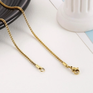 Detailed view of a gold titanium steel corn chain with lobster clasp on a clean background