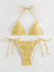 Detail of yellow floral triangle bikini set with smocked fabric and side tie bottoms