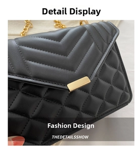 Detail of black V-quilted faux leather bag with gold chain strap and metal buckle