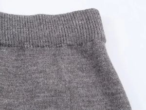 Dettaglio macro della trama in maglia di lana grigia con finitura a coste elastiche