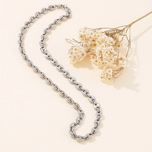 Detailed view of a silver stainless steel coffee bean link necklace with dried flowers