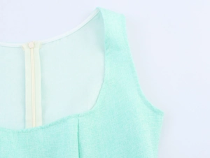 Close-up of mint green tweed dress with invisible back zipper and woven texture
