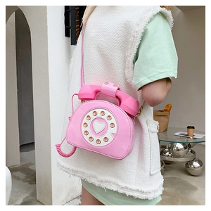 Close-up of pink patent leather crossbody bag in a vintage telephone creative design