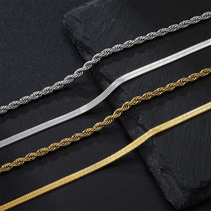Macro detail of 18k gold and silver twisted rope chains and flat herringbone necklaces