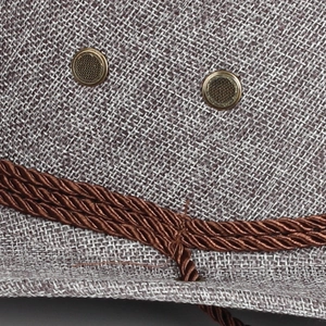 Dettaglio del tessuto in lino con occhielli di ventilazione in metallo e cordino decorativo