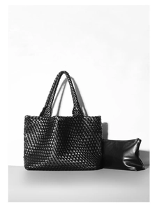 Detail of black woven tote bag with matching leather zipper inner clutch bag