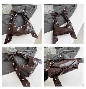 Detailansicht der dunkelbraunen Hobo-Bag aus Leder mit großer Nietenschleife und Faltenoptik