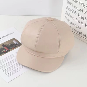 Detailed texture of beige PU leather octagonal newsboy cap on minimalist background