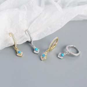 Macro detail of gold and silver S925 earrings with blue opal and white zircon stones