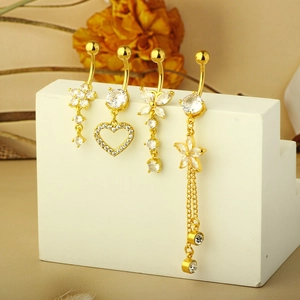 Detail of four gold belly button rings set with sparkling zircons on a display stand