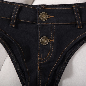 Détails du micro-short en denim noir avec coutures orange contrastées et boutons dorés