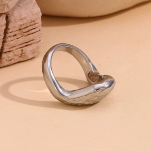 Detailed macro view of irregular streamlined silver ring with hammered texture finish