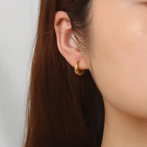 Minimalist 18K gold plated stainless steel hoop earrings worn by a model