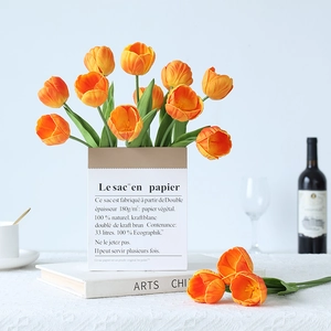 Vibrant orange artificial PU tulips in a stylish paper bag vase for home decor