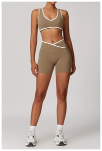 Detail of high-waist yoga shorts with V-shape cross waist and white contrast piping trim