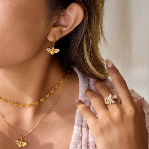 Set gioielli ape dorata con orecchini zircone, collane e anello con perla su modella