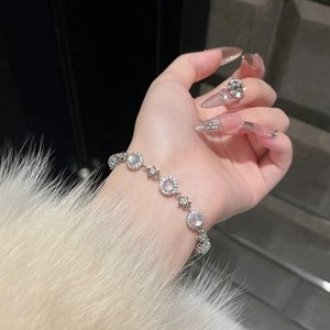 Detail of flower bracelet with chalcedony stones and zircon border on a female wrist