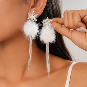 Detail of silver snowflake earrings with white fluffy balls and long chain tassels