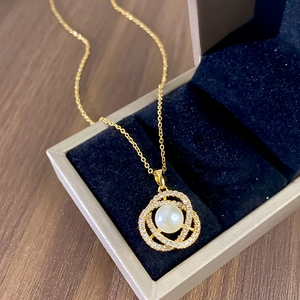 Elegant gold necklace with pearl and sparkling zircon pavé pendant in a velvet jewelry box