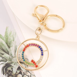 Close-up of golden letter Q keychain featuring colorful rhinestones and metal lobster clasp