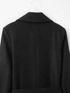 Macro view of the back collar and shoulder seams of a black twill tailored coat