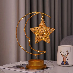 Detail of warm LED string lights inside a golden crescent moon and rattan star lamp