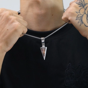 Nahaufnahme des Vintage-Pfeilspitzen-Anhängers aus Edelstahl mit Boxkette am Model