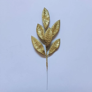 Dettaglio di foglie di pino dorate artificiali con glitter per decorazioni natalizie