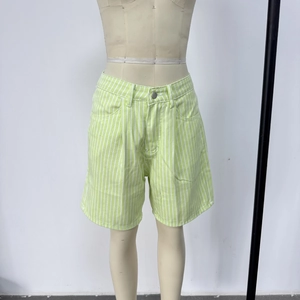 Detail of green and white vertical striped high-waisted denim shorts with button closure