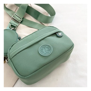 Detail of green Oxford nylon crossbody bag with adjustable wide strap and round coin purse