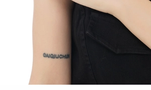 Vista detallada de las letras del tatuaje temporal GAIQUCHUN en la piel con fondo blanco