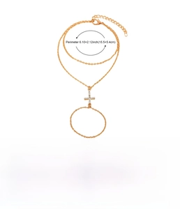 Close-up of golden finger bracelet with cross pendant and pearl chain detailing