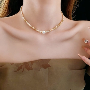 Detail of 14K gold plated necklace with shell beads and a large baroque pearl pendant