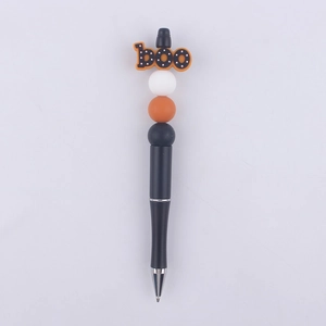 Detail of DIY beadable pen with orange boo focal bead and Halloween silicone beads