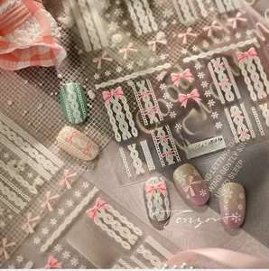 Detailed relief nail sticker featuring pink bows, white snowflakes, and sweater textures